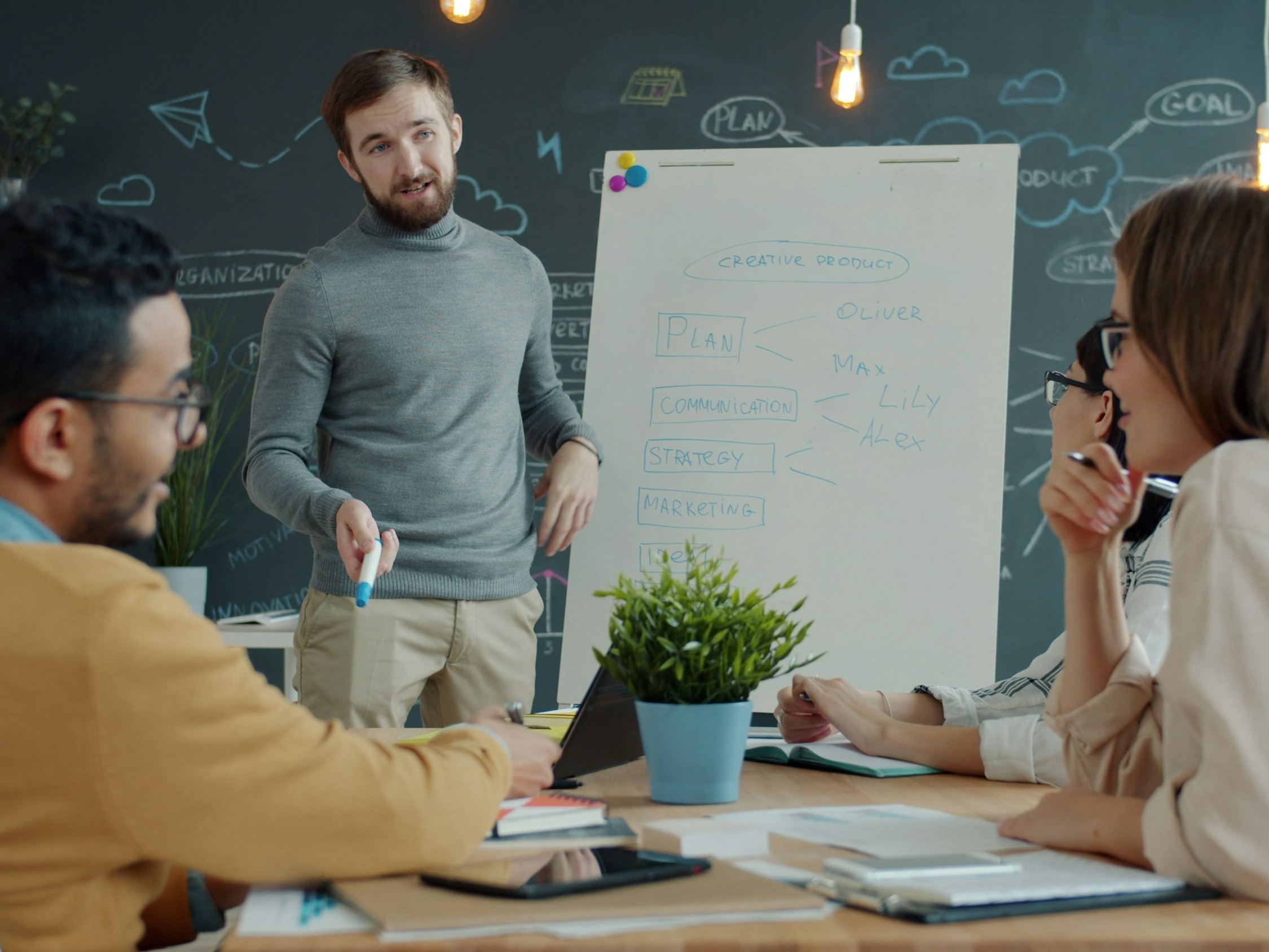 Diverse team of business professionals collaborating around a whiteboard during a strategy session